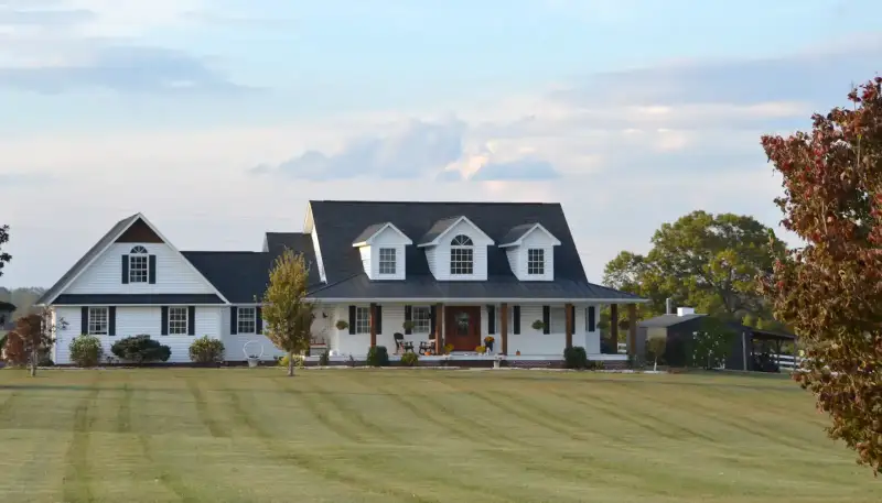 A white farmhouse with a big front lawn